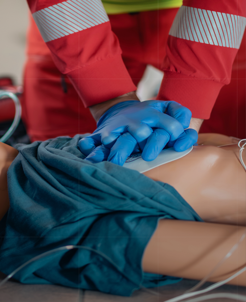CPR training on mannequin with blue gloves.