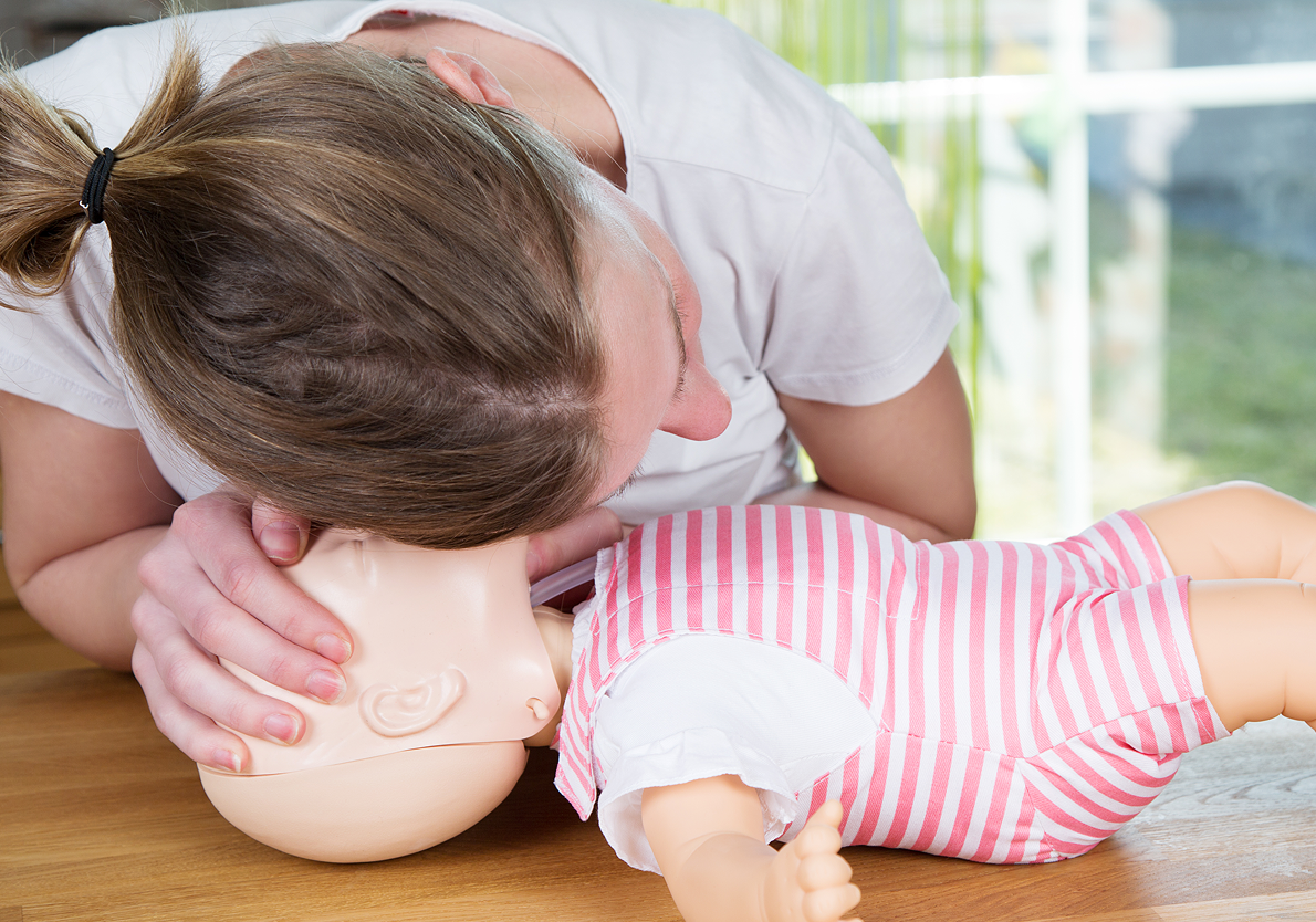 CPR training on infant mannequin.