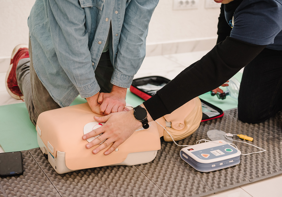 CPR training on a mannequin with defibrillator.