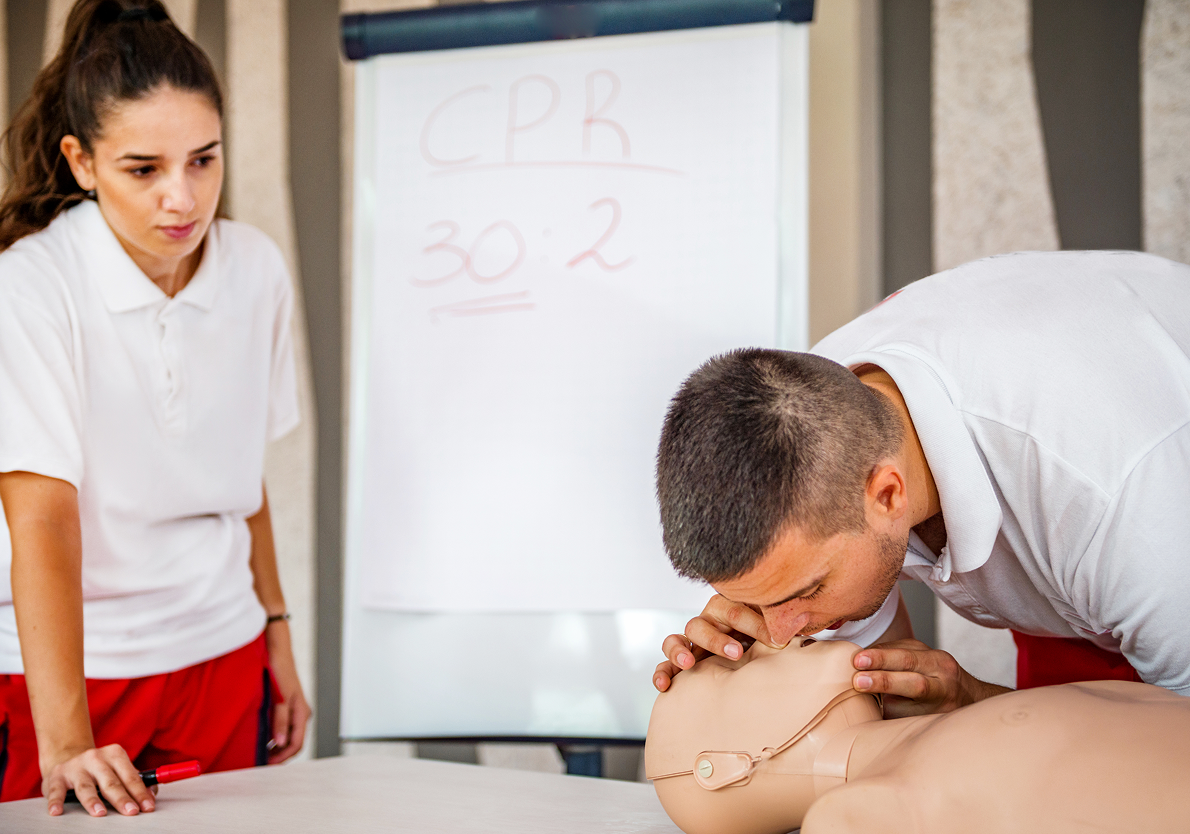 Man practicing CPR on a dummy mannequin.